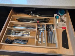 un cajón de madera con utensilios. en EV Housing Rental, en Fargo