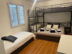 a bedroom with two bunk beds and a window at Chambres dans maison avec piscine toboggan aquatique et spa in Saint-Mars-la-Brière