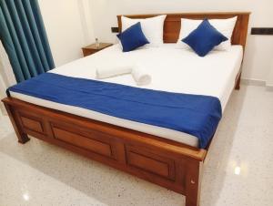 een groot bed met blauwe en witte kussens erop bij SandaLuck House Ahangama in Ahangama