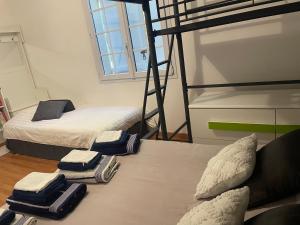 two beds in a room with two bunk beds at Chambres dans maison avec piscine toboggan aquatique et spa in Saint-Mars-la-Brière