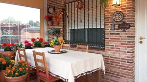 a table with chairs and flowers on a patio at Casa Rural Dani Escalona in Toledo