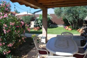 a table and chairs in a yard with flowers at Casa Rural Dani. Escalona in Toledo