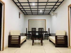 a dining room with wooden chairs and a table at Regalia Wayanad in Kalpetta