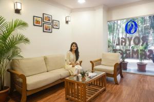 a woman sitting on a couch in a living room at Via Royal Samrat - Ram Manohar Lohiya in Pune
