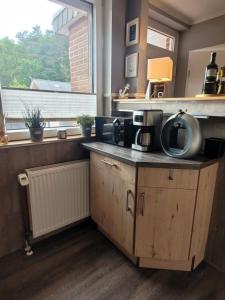 eine Küche mit einer Theke mit einer Mikrowelle und einem Fenster in der Unterkunft Ferienhaus Düne 16 in Berumbur