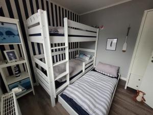 ein Schlafzimmer mit zwei Etagenbetten und einem kleinen Bett in der Unterkunft Ferienhaus Düne 16 in Berumbur + 9 Fotos