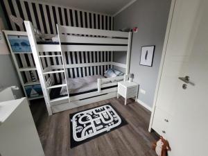 ein Zimmer mit zwei Etagenbetten und einem Teppich in der Unterkunft Ferienhaus Düne 16 in Berumbur