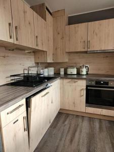 eine Küche mit Holzschränken und einem schwarzen Gerät in der Unterkunft Ferienhaus Düne 16 in Berumbur