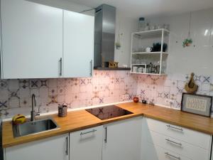 a kitchen with white cabinets and a sink at Casa Fuente del Caño in Casarabonela +22 photos