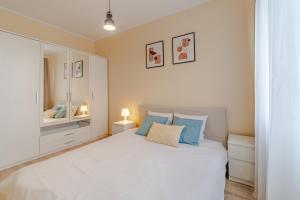 a bedroom with a large white bed with blue pillows at Apartament Odrzańskie Tarasy, Klimatyzacja, PW INVEST HOME in Krapkowice