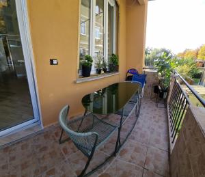 a glass table and chairs on a balcony at Sunny CentralApartment -3 bedrooms ,Private Parking in Monfalcone