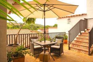 a table and chairs with an umbrella on a balcony at Hotel Boutique Casa Encanto Barichara in Barichara
