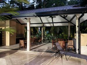 a pavilion with chairs and tables on a patio at Vistas del Bosque Jacó in Jacó