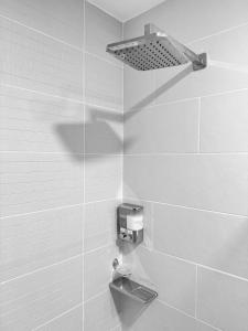 a bathroom with a shower with a soap dispenser on the wall at Vistas del Bosque Jacó in Jacó