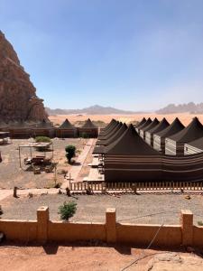 un groupe de tentes noires dans le désert dans l'établissement Abdallah shaheen wadi rum, à Disah