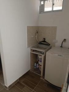 a small kitchen with a sink and a washing machine at Apartamento amoblado in Girardot +1 photo