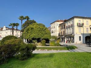 a group of buildings with palm trees and a park at Cozy Apartment Mati Lago Maggiore in Verbania