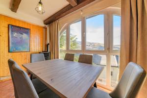 a dining room with a table and chairs and a large window at Chalet Copos Nevados by Surynieve in Sierra Nevada