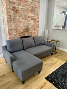 a couch in a living room with a brick wall at Highland Apartment in Columbus