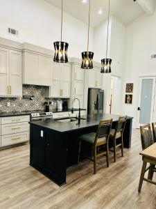een keuken met witte kasten en een zwart eiland bij Deluxe Fun House - Pet Friendly in Piney