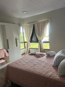 Un dormitorio con una cama y una ventana grande. en Pousada Ypê, en São Lourenço do Oeste