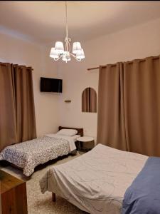 a bedroom with two beds and a chandelier at Ermis Hotel in Dhríza