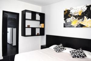 a bedroom with a black and white bed with pillows at Bounaterra Lofts in León