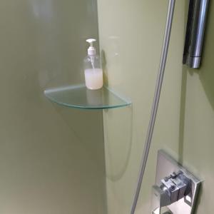 a bottle of soap sitting on a glass shelf in a bathroom at Vortex luxury apartment by KL in Kuala Lumpur +14 photos