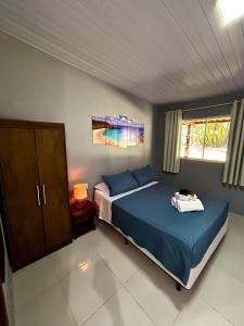 Un dormitorio con una cama con sábanas azules y un armario. en Paraíso do Boldró Flat, en Fernando de Noronha