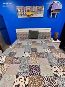 a bed with a quilt on it in a room at Fully furnished bedroom c-136 in Abu Dhabi