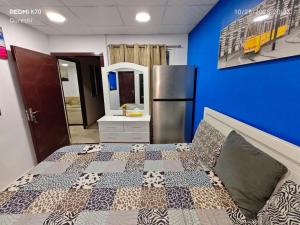 a bedroom with a bed and a refrigerator at Fully furnished bedroom c-136 in Abu Dhabi
