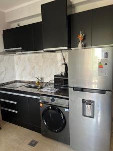 a kitchen with a refrigerator and a washing machine at Departamento amoblado centro capital in San Juan +6 photos