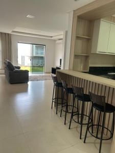 sala de estar con cocina y bar con taburetes en Pousada Ypê, en São Lourenço do Oeste