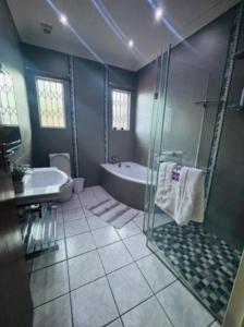 a bathroom with a shower and a tub and a sink at Dream vacation home in Vanderbijlpark +15 photos