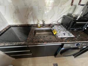 a kitchen counter with a sink and a microwave at Departamento amoblado centro capital in San Juan