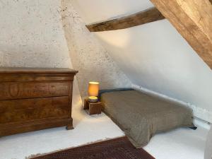 a bedroom with a bed and a dresser in a attic at La maison du moulin in Lurcy-le-Bourg +2 photos