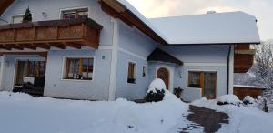 a house with snow in front of it at Appartement Silvia in Oberweissburg