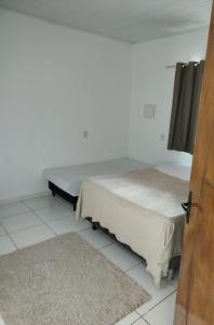 une chambre avec un lit et un tapis dans l'établissement Ambiente Família e acolhedor, à Porto Seguro