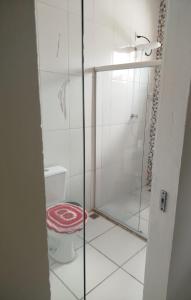 une salle de bain avec toilettes et douche en verre dans l'établissement Ambiente Família e acolhedor, à Porto Seguro 7 autres photos