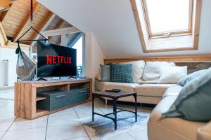 a living room with a tv and a couch at Ferienwohnung in Strittberg mit Sauna und Alpenblick in Höchenschwand