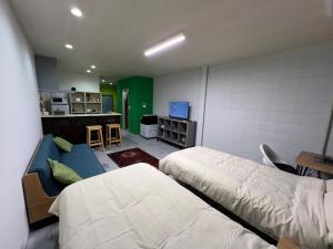 a bedroom with two beds and a couch and a kitchen at uchimachi201 しげの里リノベーション52平方メートルJR高松駅14分ことでん片原町駅3分土足OK in Takamatsu +32 photos