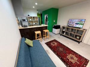a living room with a blue couch and a tv at uchimachi201 しげの里リノベーション52平方メートルJR高松駅14分ことでん片原町駅3分土足OK in Takamatsu