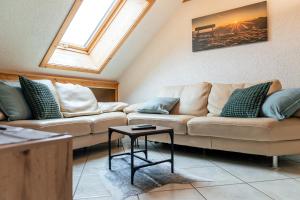 a living room with two couches and a table at Ferienwohnung in Strittberg mit Sauna und Alpenblick in Höchenschwand