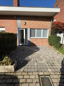 a brick building with a driveway in front of it at WelKom Studios in Zaventem
