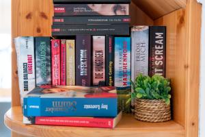a stack of books on a book shelf at Ferienwohnung in Strittberg mit Sauna und Alpenblick in Höchenschwand +34 photos