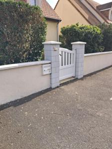 a white fence in front of a house at Studio des cygnes in Le Mans