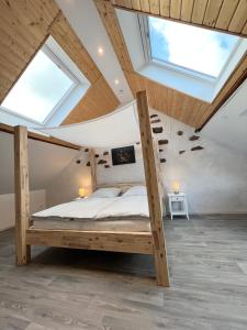 een slaapkamer met een bed op een zolder met dakramen bij Haus am Bach in Schleiden