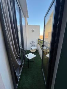 Un balcón con una silla, una mesa y una ventana en Furnished Apartment High Standing Quiet and Secure, en Kenitra