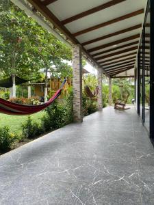 a porch with a hammock and a swing at Cómoda Finca de Descanso en Urabá in Estación El Salto
