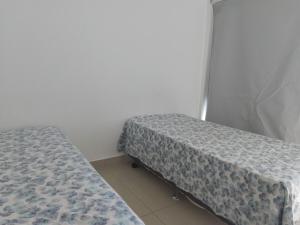 Ένα ή περισσότερα κρεβάτια σε δωμάτιο στο Lar Hospedagens - Mar Bello